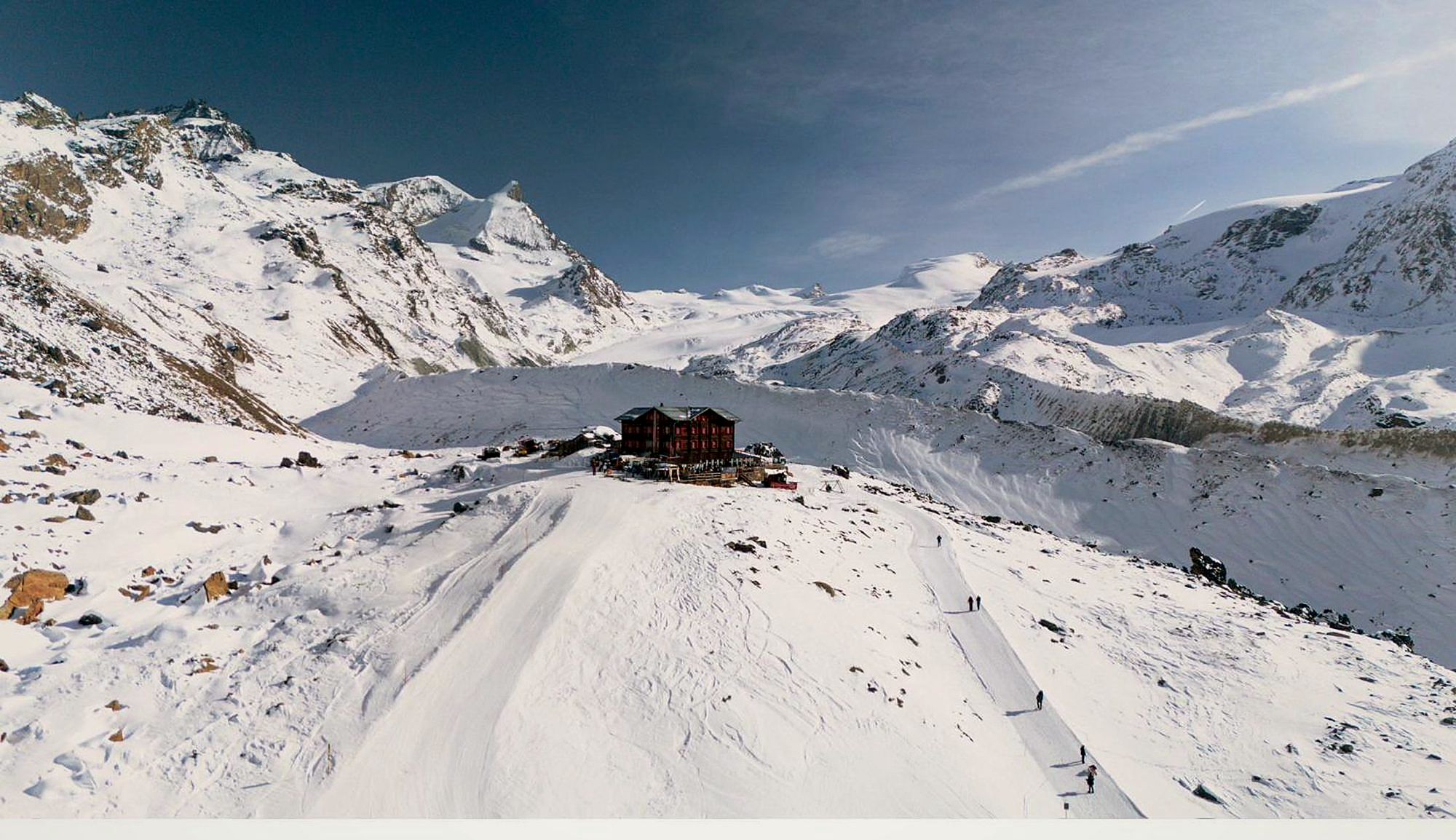 A mountain chalet above Zermatt, guests ascending the piste toward the Matterhorn