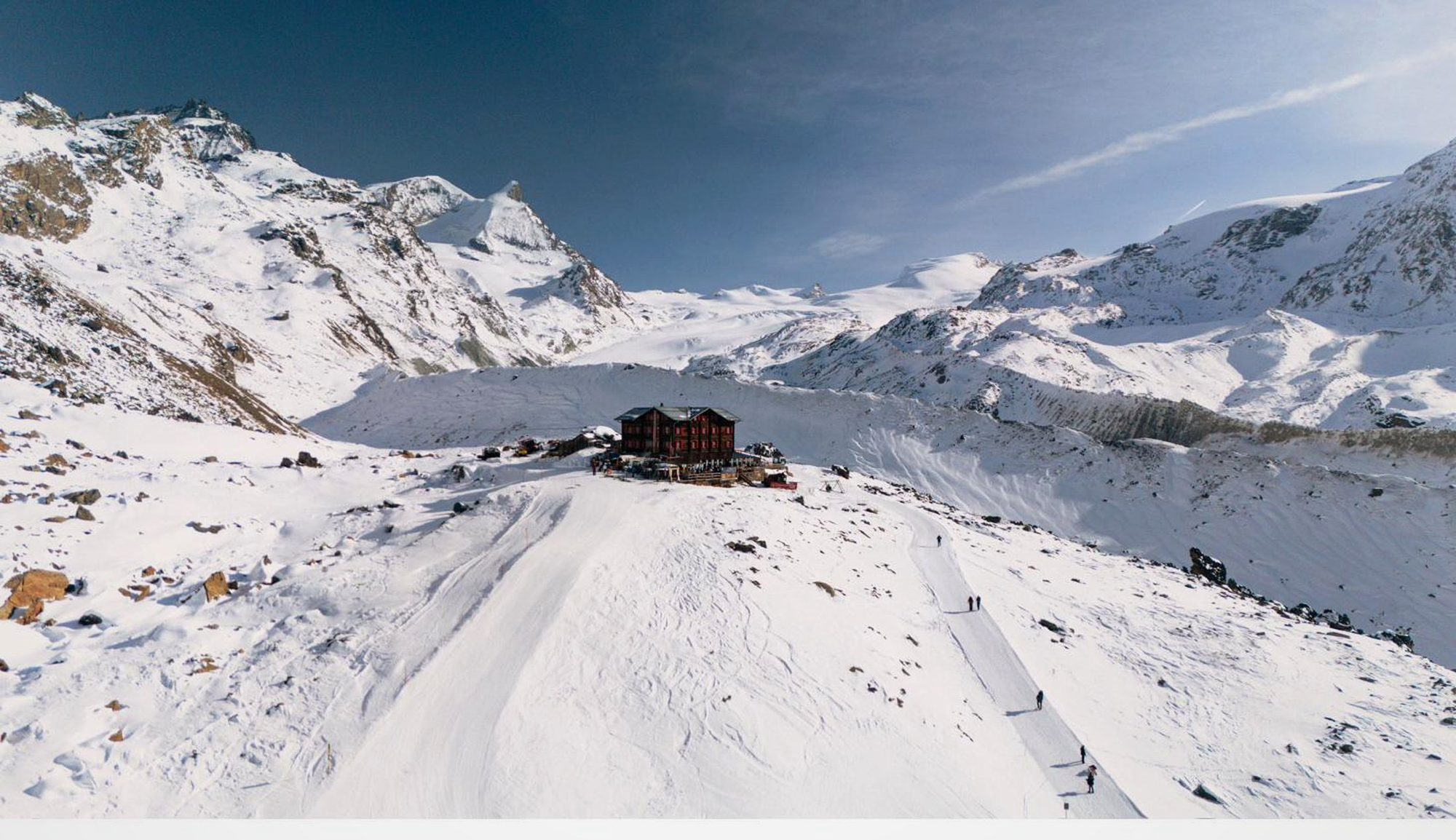 A mountain chalet above Zermatt, guests ascending the piste toward the Matterhorn